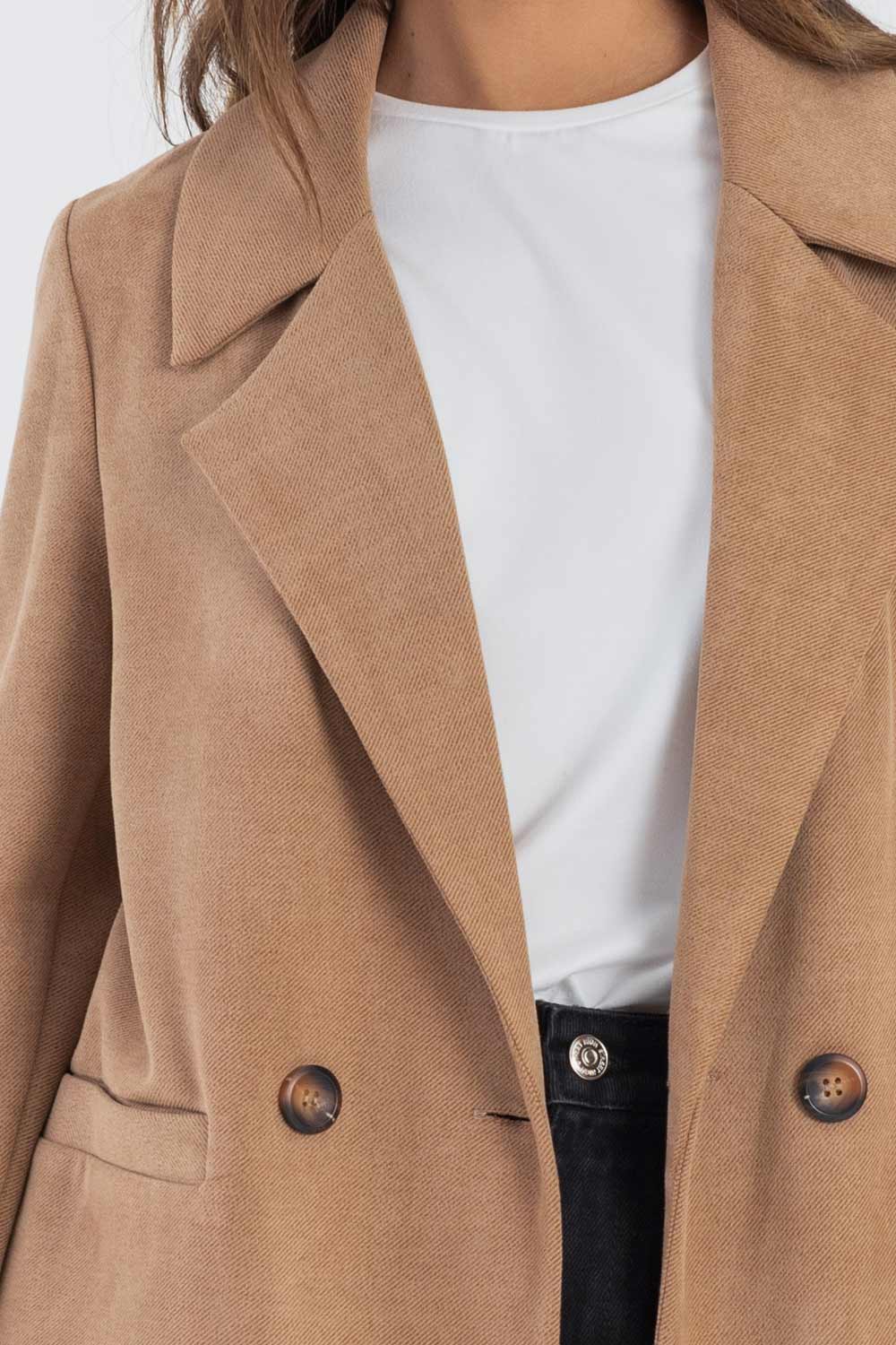 Abrigo de fit recto, manga larga, con solapa y hombreras, bolsillos delanteros con vivos y cierre frontal con doble cruce de botones en contraste.