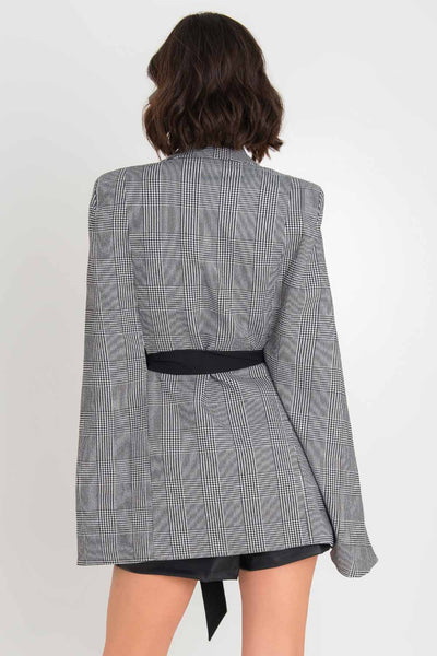 Abrigo de manga capa, estampado glenn check, con solapa, trabillas en cintura, bolsillos delanteros con vivos y cinturón amarrable en contraste.