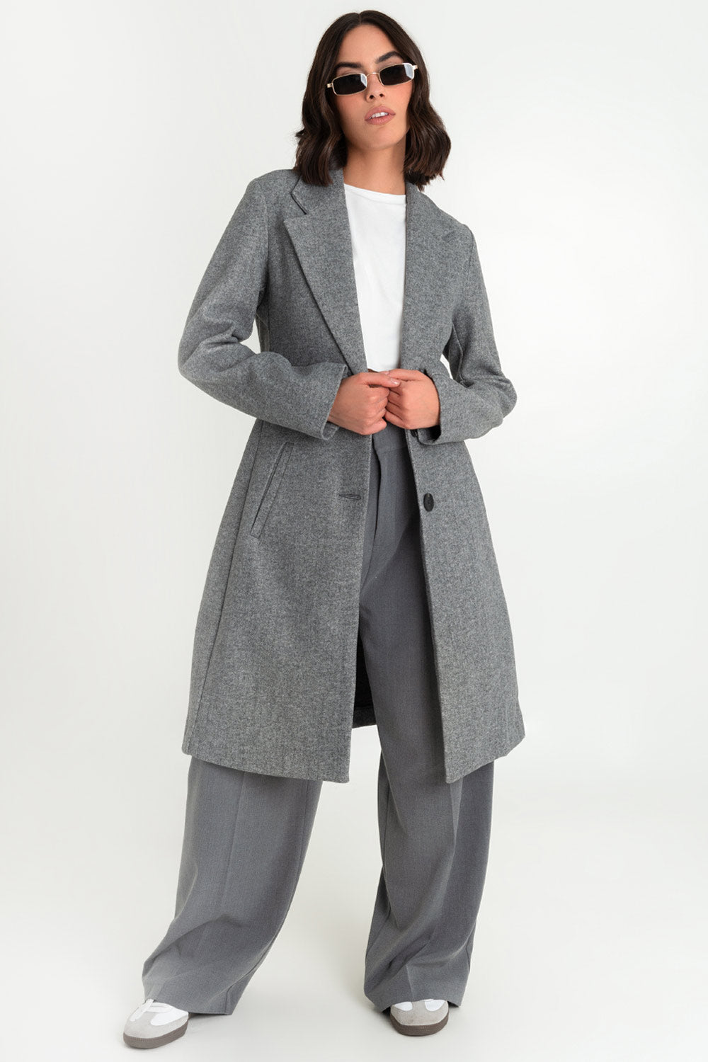 Abrigo largo de fit recto, con solapa y hombreras, manga larga, bolsillos delanteros con vivos y cierre frontal con botones en contraste.