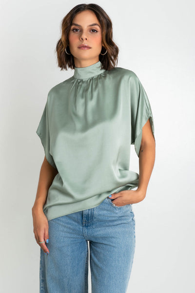 Blusa satinada de fit oversized, manga corta seguida, cuello alto con detalles plisados, bajo curveado y cierre posterior lazo amarrable.