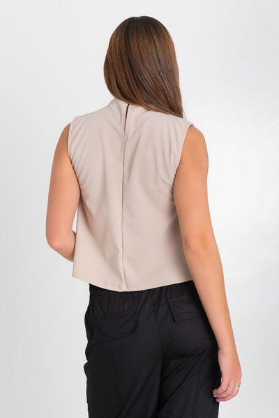 Blusa sin mangas de fit recto, cuello mock con detalles plisados y cierre posterior con botón y ojal.