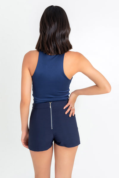 Falda short asimétrico de cintura alta, pretina y cierre posterior con cremallera visible.