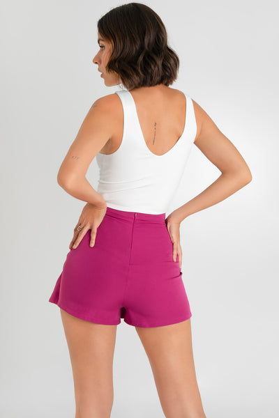 Falda short con abertura frontal, cintura alta con pretina, corte en a y cierre posterior con cremallera oculta.