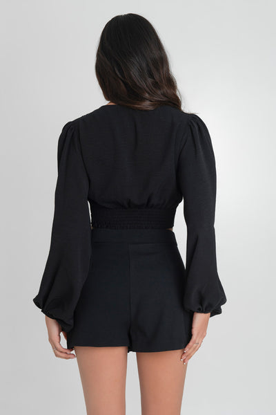 Falda short corto de cintura alta con pretina elástica, corte en a y aberturas frontales decorativas.