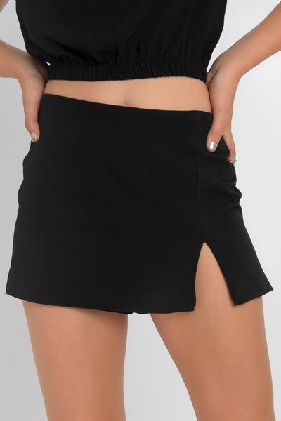 Falda short corto de cintura alta, corte en a, costura frontal con abertura en bajo y cierre posterior con cremallera oculta.