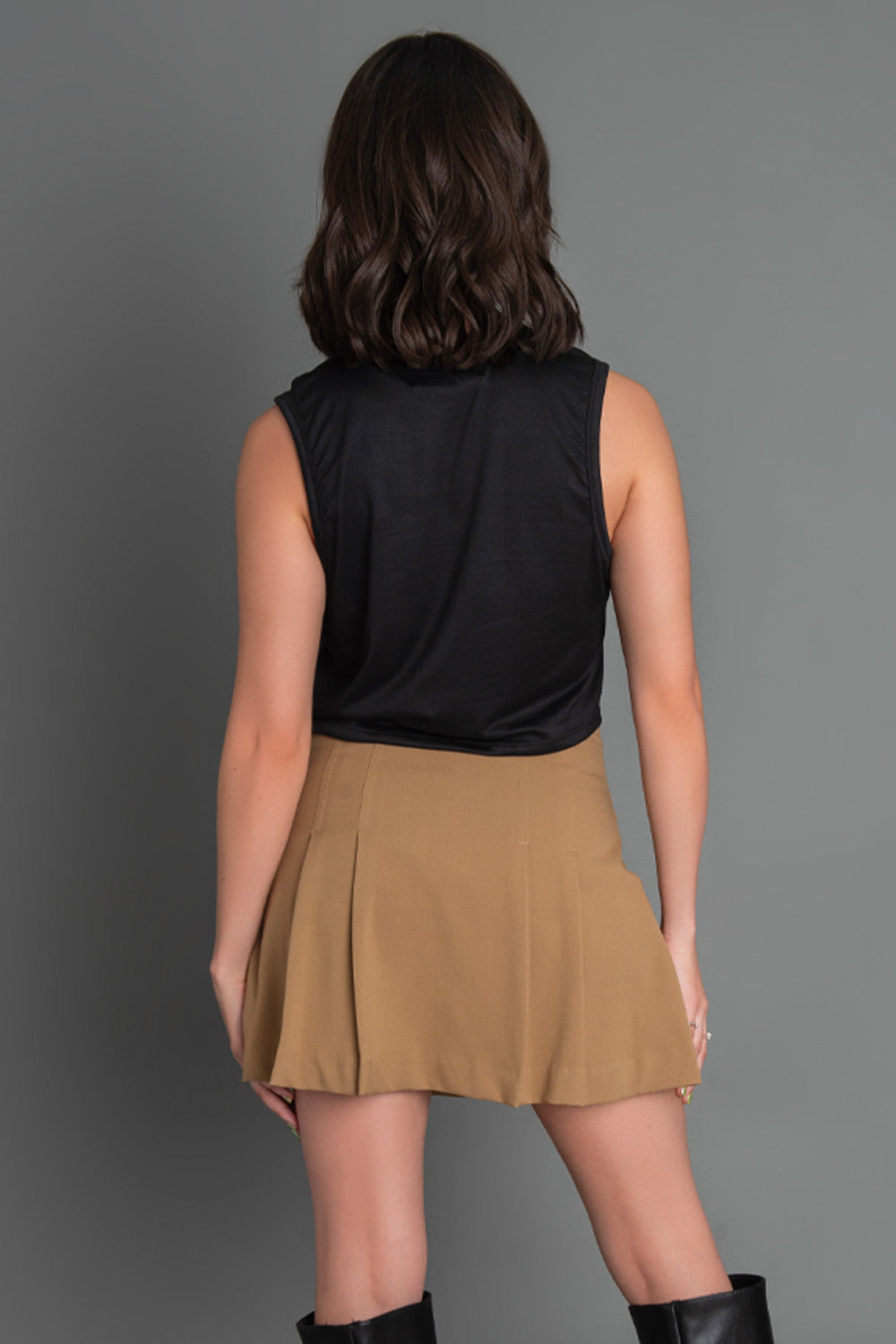 Falda short corto tableado de cintura alta, corte en a y cierre lateral con cremallera oculta.