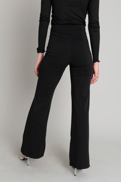 Pantalón ajustado de fit flare, cintura alta con pretina, aberturas interiore en bajo, cierre frontal con botón y cremallera oculta.