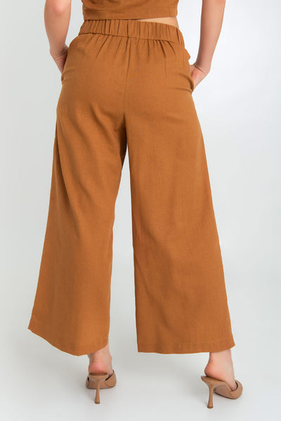 Pantalón de lino, fit culotte, cintura alta con pretina elástica posterior y trabillas, bolsillos delanteros y pinzas frontales.