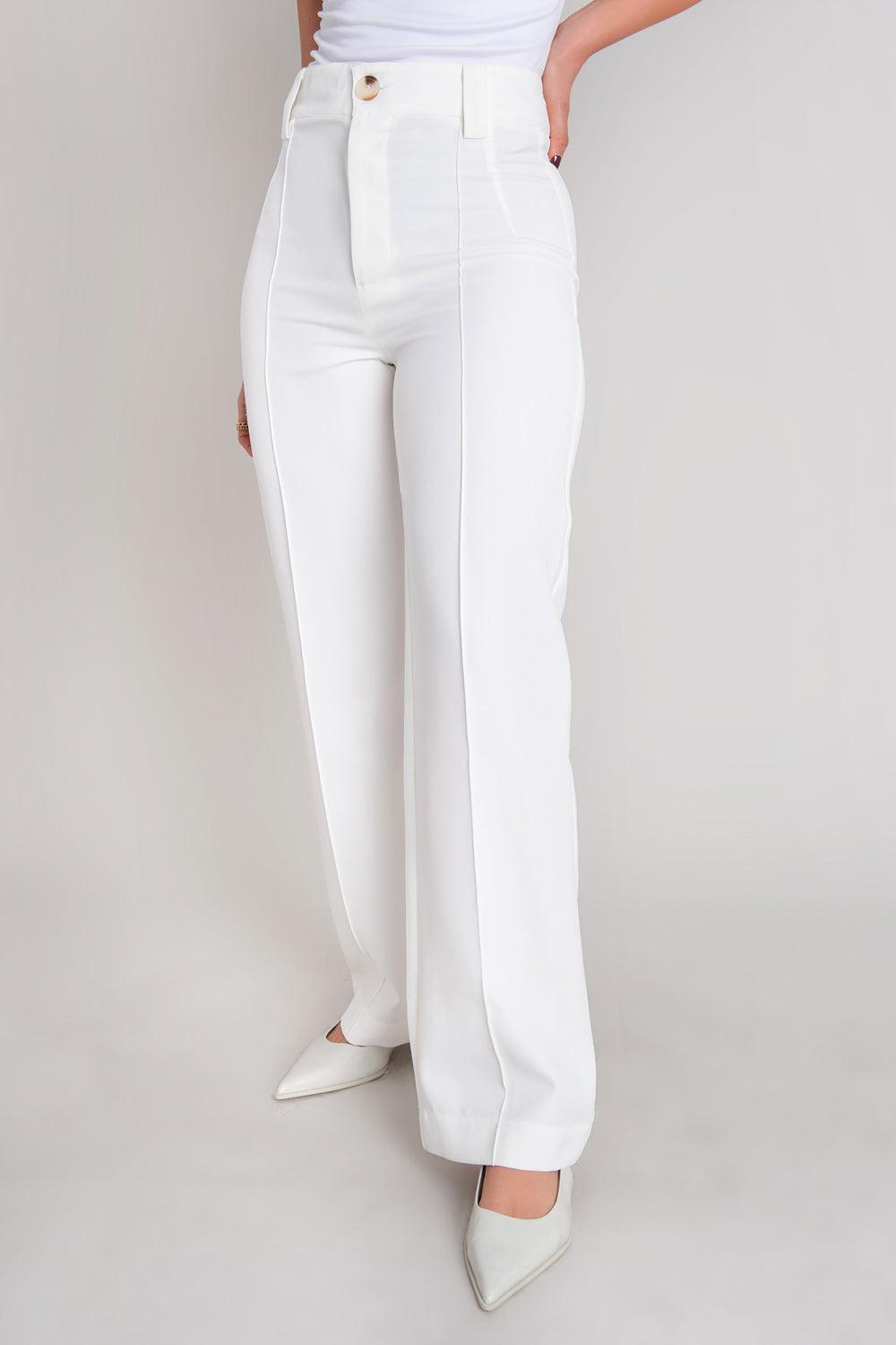 Pantalón ajustado de fit recto, cintura alta con pretina y trabillas, detalle de raya frontal, cierre con botón en contraste y cremallera oculta.