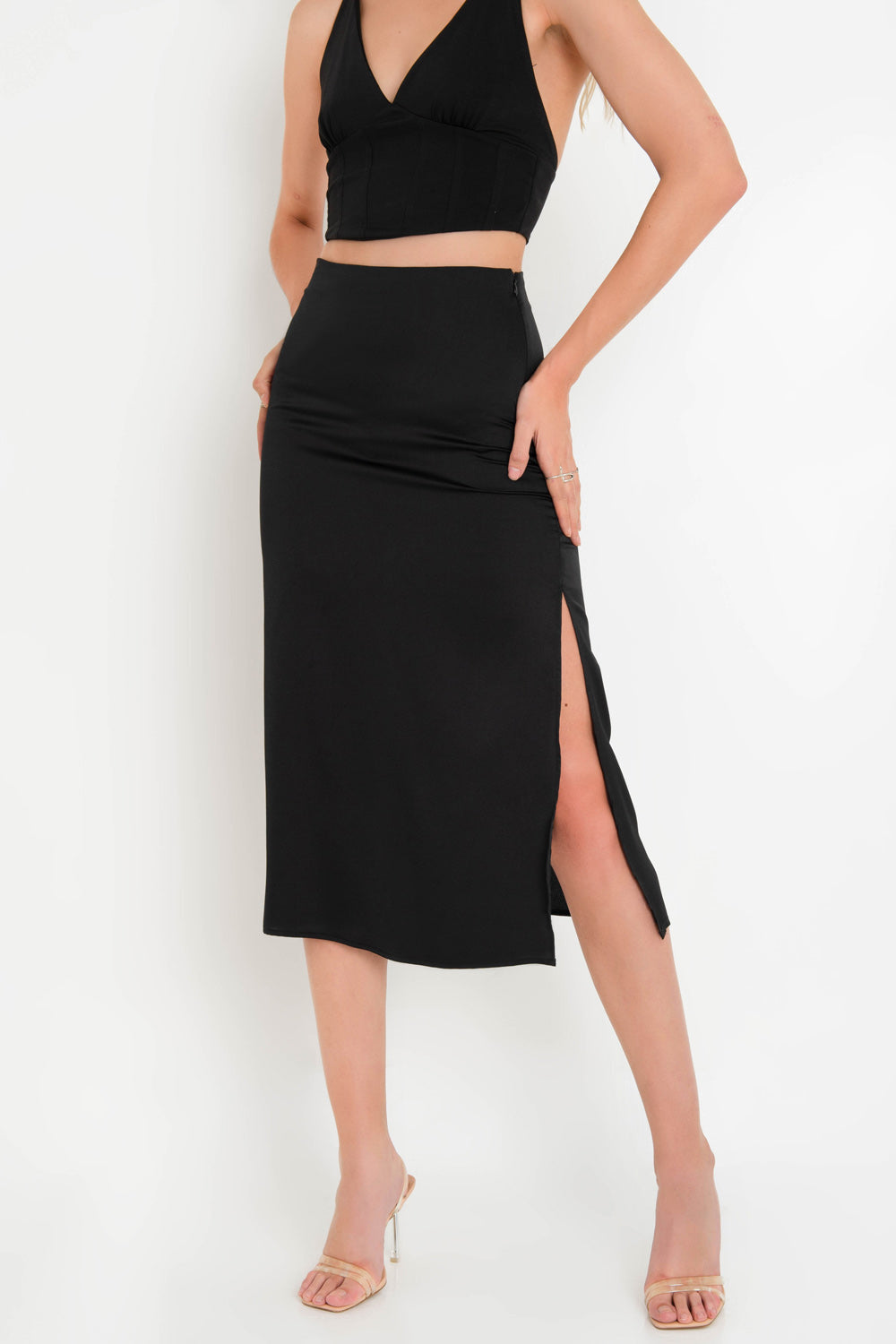 Falda midi ajustada de fit recto, cintura alta y abertura lateral en bajo. Cierre lateral con cremallera oculta