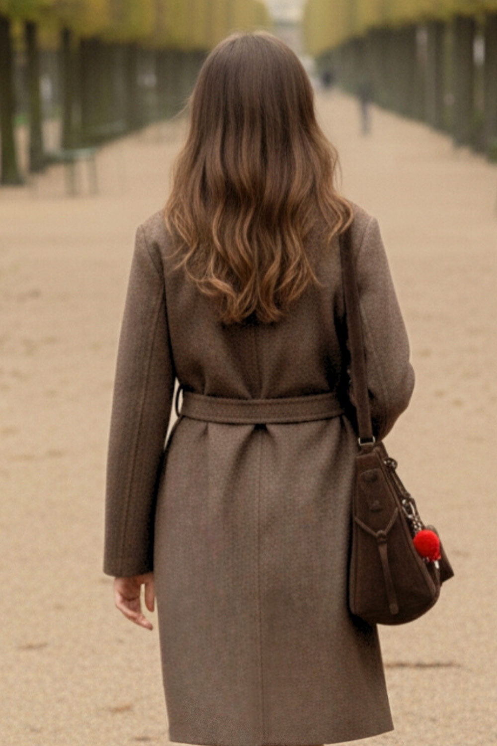 Abrigo largo de manga larga, con solapa, bolsillos delanteros de parche, trabillas y cinturón amarrable del mismo tejido.