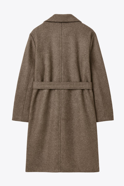 Abrigo largo de manga larga, con solapa, bolsillos delanteros de parche, trabillas y cinturón amarrable del mismo tejido.