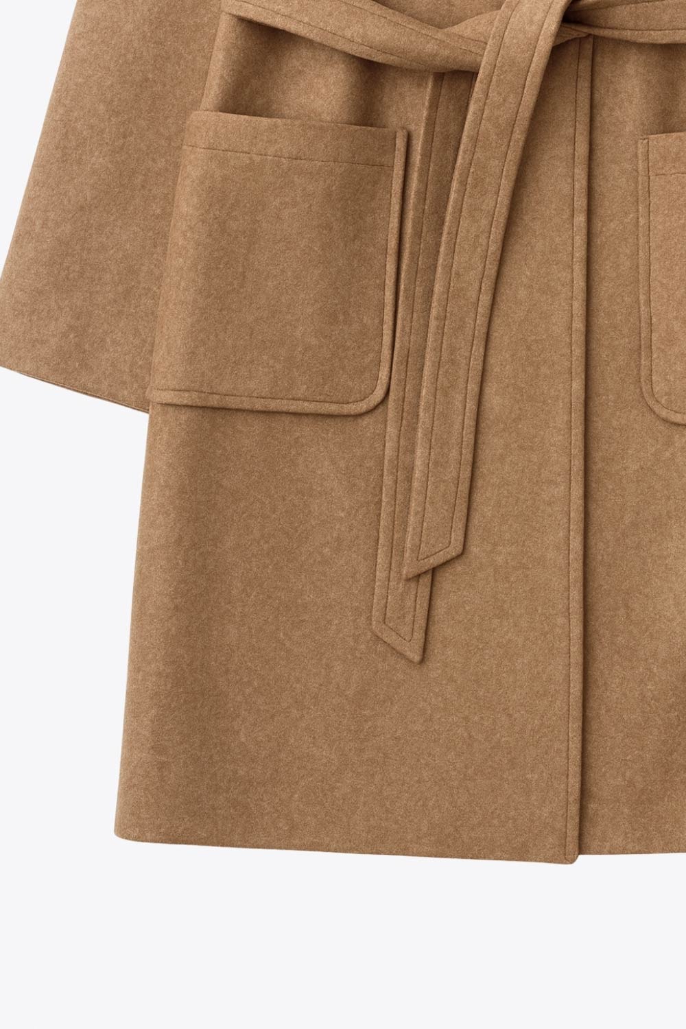 Abrigo largo de manga larga, con solapa, bolsillos delanteros de parche, trabillas y cinturón amarrable del mismo tejido.