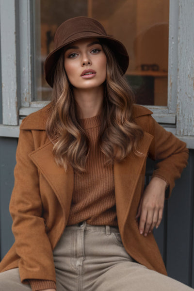 Abrigo abierto de gamuza, corte en a, con solapa y hombreras, manga larga, bolsillos delanteros ocultos, trabillas y cinturón amarrable del mismo tejido.