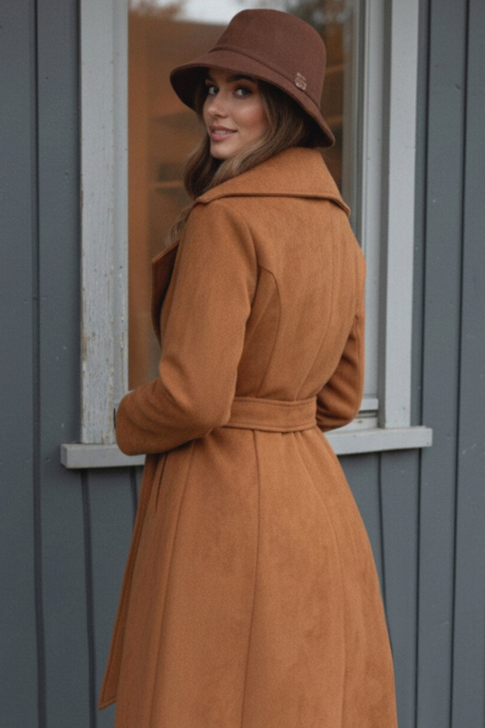 Abrigo abierto de gamuza, corte en a, con solapa y hombreras, manga larga, bolsillos delanteros ocultos, trabillas y cinturón amarrable del mismo tejido.