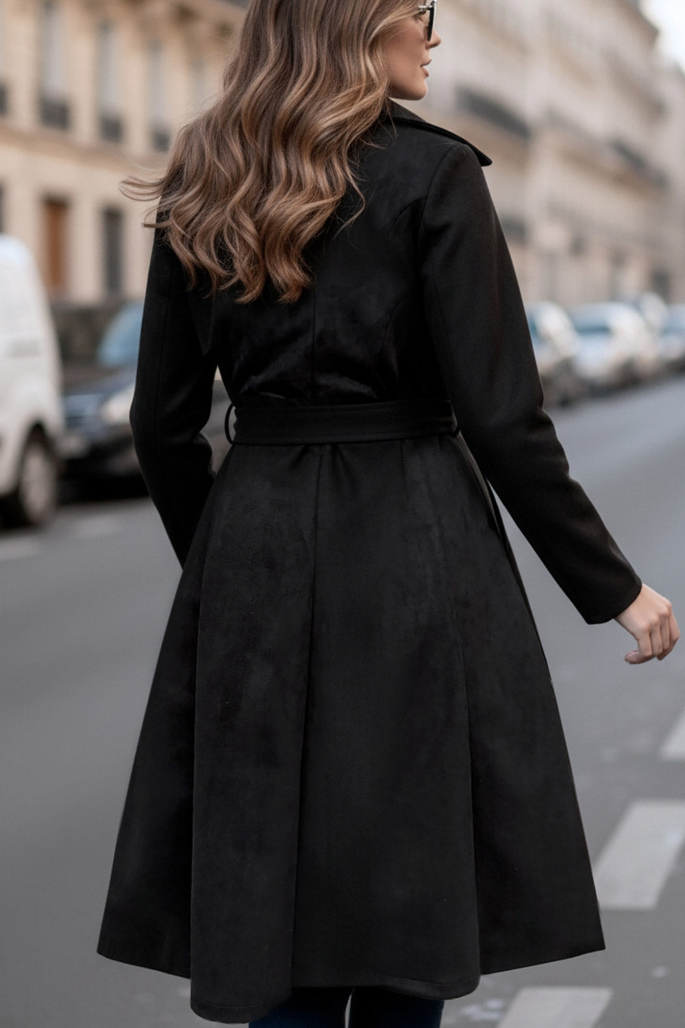 Abrigo abierto de gamuza, corte en a, con solapa y hombreras, manga larga, bolsillos delanteros ocultos, trabillas y cinturón amarrable del mismo tejido.