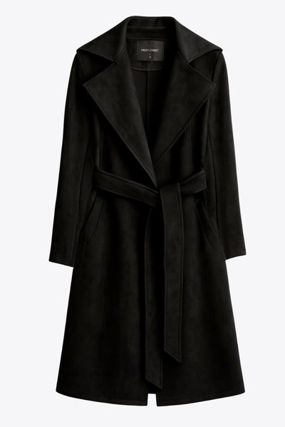 Abrigo abierto de gamuza, corte en a, con solapa y hombreras, manga larga, bolsillos delanteros ocultos, trabillas y cinturón amarrable del mismo tejido.