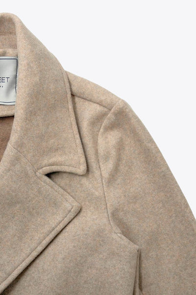 Abrigo de fit recto, con solapa, manga larga, bolsillos frontales con vivos, trabillas y cinturón amarrable del mismo tejido.