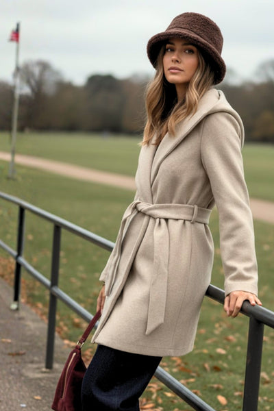 Abrigo de fit recto con capucha, manga larga y bolsillos delanteros. Detalle de trabillas y cinturón amarrable del mismo tejido.