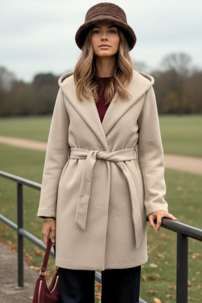 Abrigo de fit recto con capucha, manga larga y bolsillos delanteros. Detalle de trabillas y cinturón amarrable del mismo tejido.