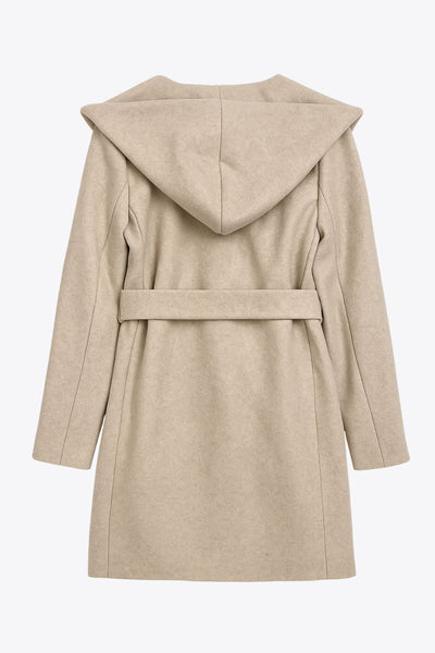 Abrigo de fit recto con capucha, manga larga y bolsillos delanteros. Detalle de trabillas y cinturón amarrable del mismo tejido.