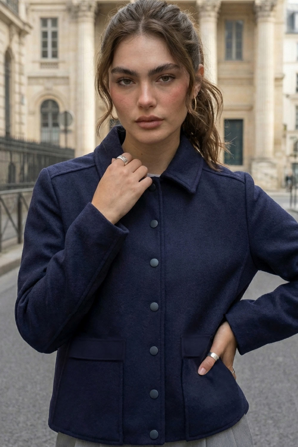 Abrigo corto de fit recto, manga larga, cuello solapa, bolsillos delanteros de parche con cartera y cierre frontal con hilera de botones en contraste.