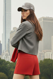 Abrigo corto de fit recto, manga larga, cuello solapa, bolsillos delanteros de parche con cartera y cierre frontal con hilera de botones en contraste.