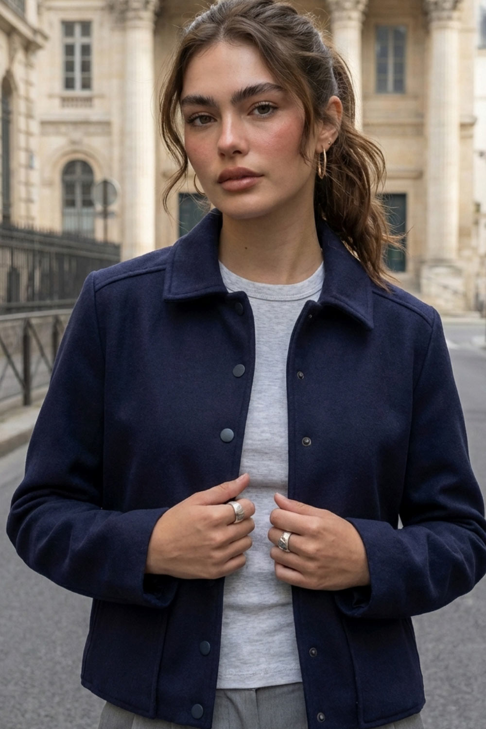 Abrigo corto de fit recto, manga larga, cuello solapa, bolsillos delanteros de parche con cartera y cierre frontal con hilera de botones en contraste.