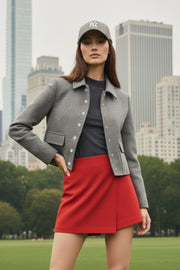 Abrigo corto de fit recto, manga larga, cuello solapa, bolsillos delanteros de parche con cartera y cierre frontal con hilera de botones en contraste.