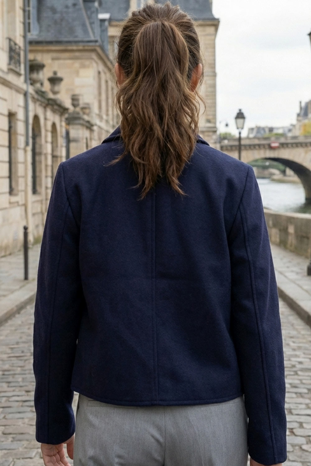 Abrigo corto de fit recto, manga larga, cuello solapa, bolsillos delanteros de parche con cartera y cierre frontal con hilera de botones en contraste.