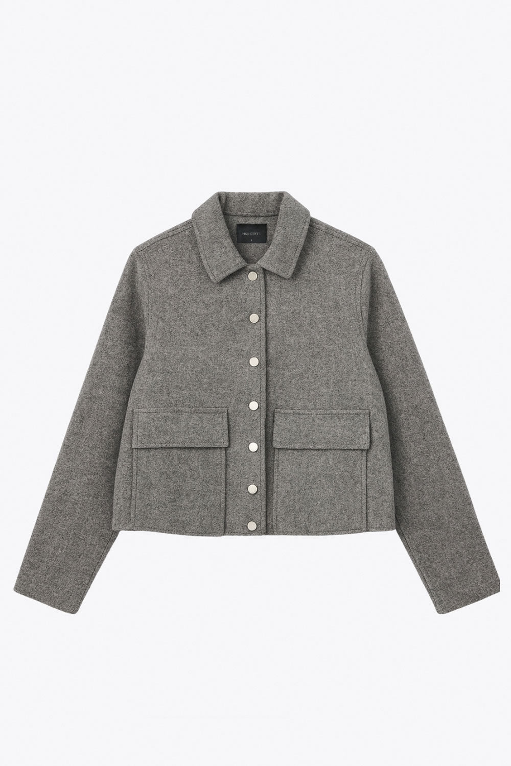 Abrigo corto de fit recto, manga larga, cuello solapa, bolsillos delanteros de parche con cartera y cierre frontal con hilera de botones en contraste.