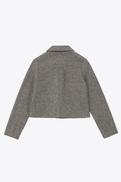 Abrigo corto de fit recto, manga larga, cuello solapa, bolsillos delanteros de parche con cartera y cierre frontal con hilera de botones en contraste.