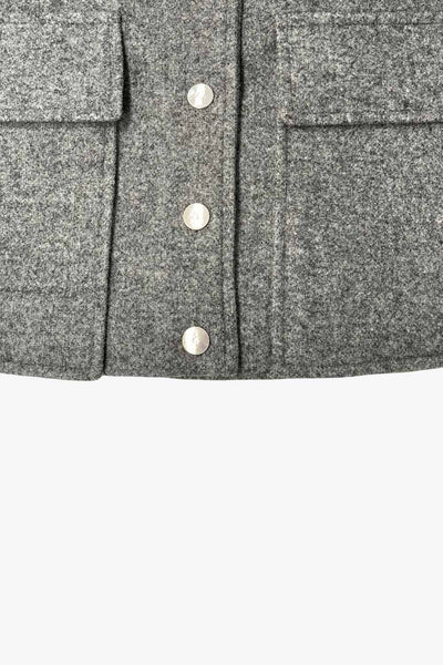 Abrigo corto de fit recto, manga larga, cuello solapa, bolsillos delanteros de parche con cartera y cierre frontal con hilera de botones en contraste.