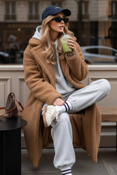 Abrigo largo de borreguillo, fit recto, con solapa, manga larga y bolsillos delanteros con vivos. Cierre frontal con botón en contraste.