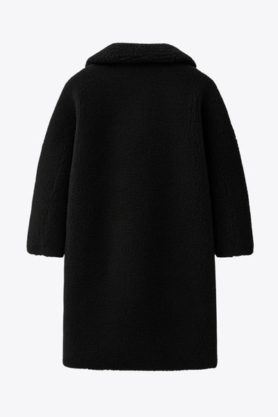 Abrigo largo de borreguillo, fit recto, con solapa, manga larga y bolsillos delanteros con vivos. Cierre frontal con botón en contraste.