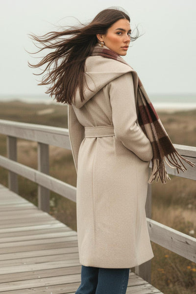 Abrigo largo de fit recto con capucha, manga larga y bolsillos delanteros. Detalle de trabillas y cinturón amarrable del mismo tejido.