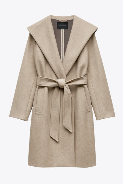 Abrigo largo de fit recto con capucha, manga larga y bolsillos delanteros. Detalle de trabillas y cinturón amarrable del mismo tejido.