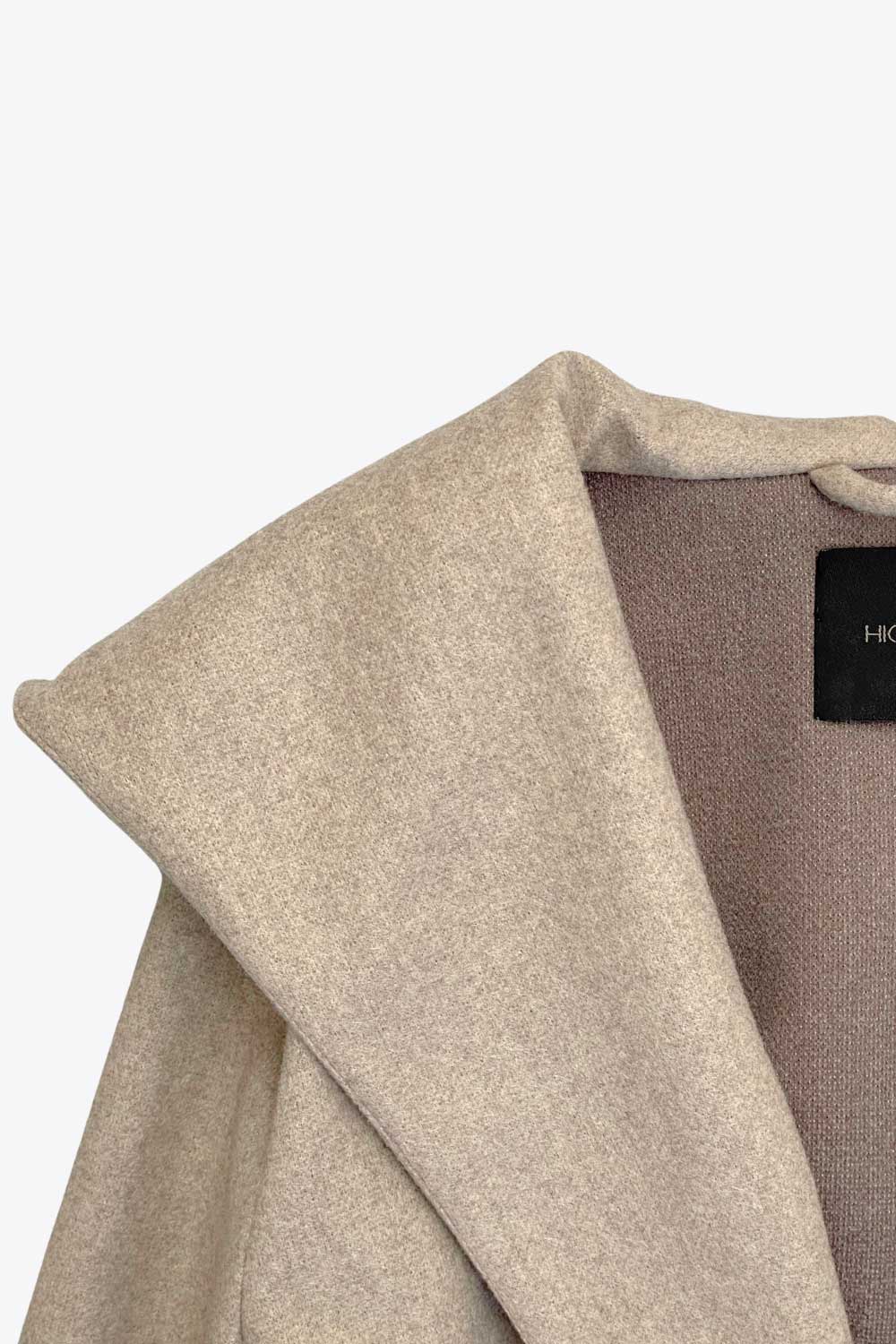 Abrigo largo de fit recto con capucha, manga larga y bolsillos delanteros. Detalle de trabillas y cinturón amarrable del mismo tejido.