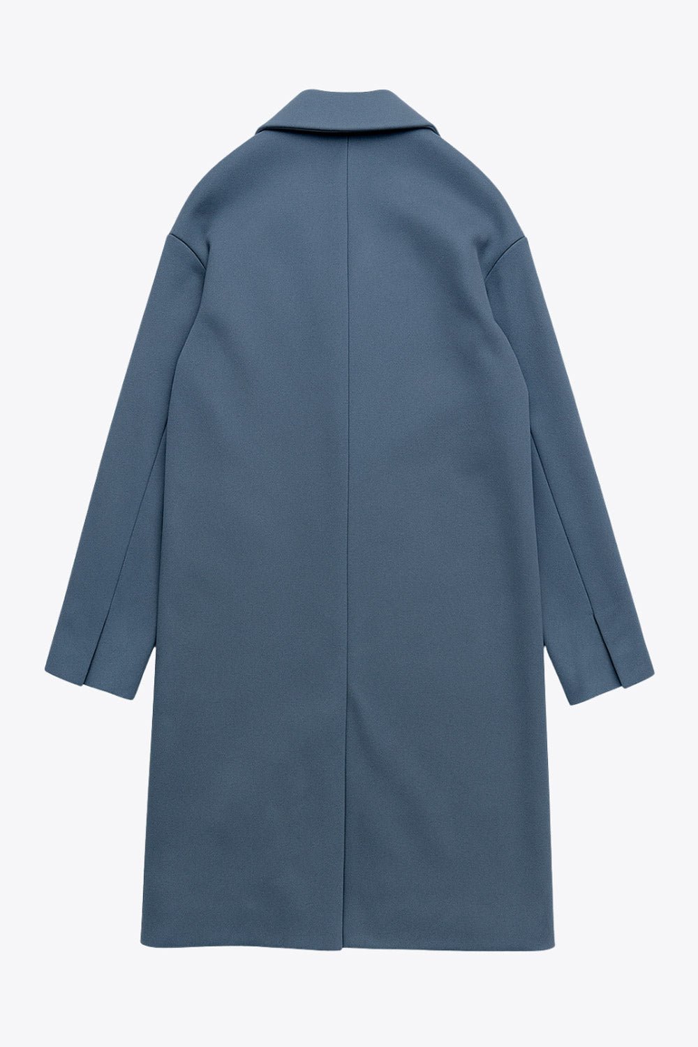 Abrigo largo de fit recto, con solapa, manga larga y bolsillos frontales con cartera. Cierre frontal con botón en contraste y detalle de abertura posterior.