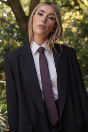 Abrigo largo de fit recto, manga larga, con solapa y hombreras, bolsillos delanteros con cartera y cierre frontal con cruce de botones. Detalle de abertura posterior en bajo.