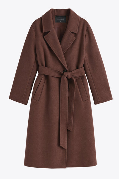 Abrigo largo de fit recto con solapa, manga larga con puños abotonados y bolsillos delanteros con vivos. Cierre frontal con doble cruce de botones. Detalle de abetura posterior en bajo, trabillas y cinturón amarrable del mismo tejido.