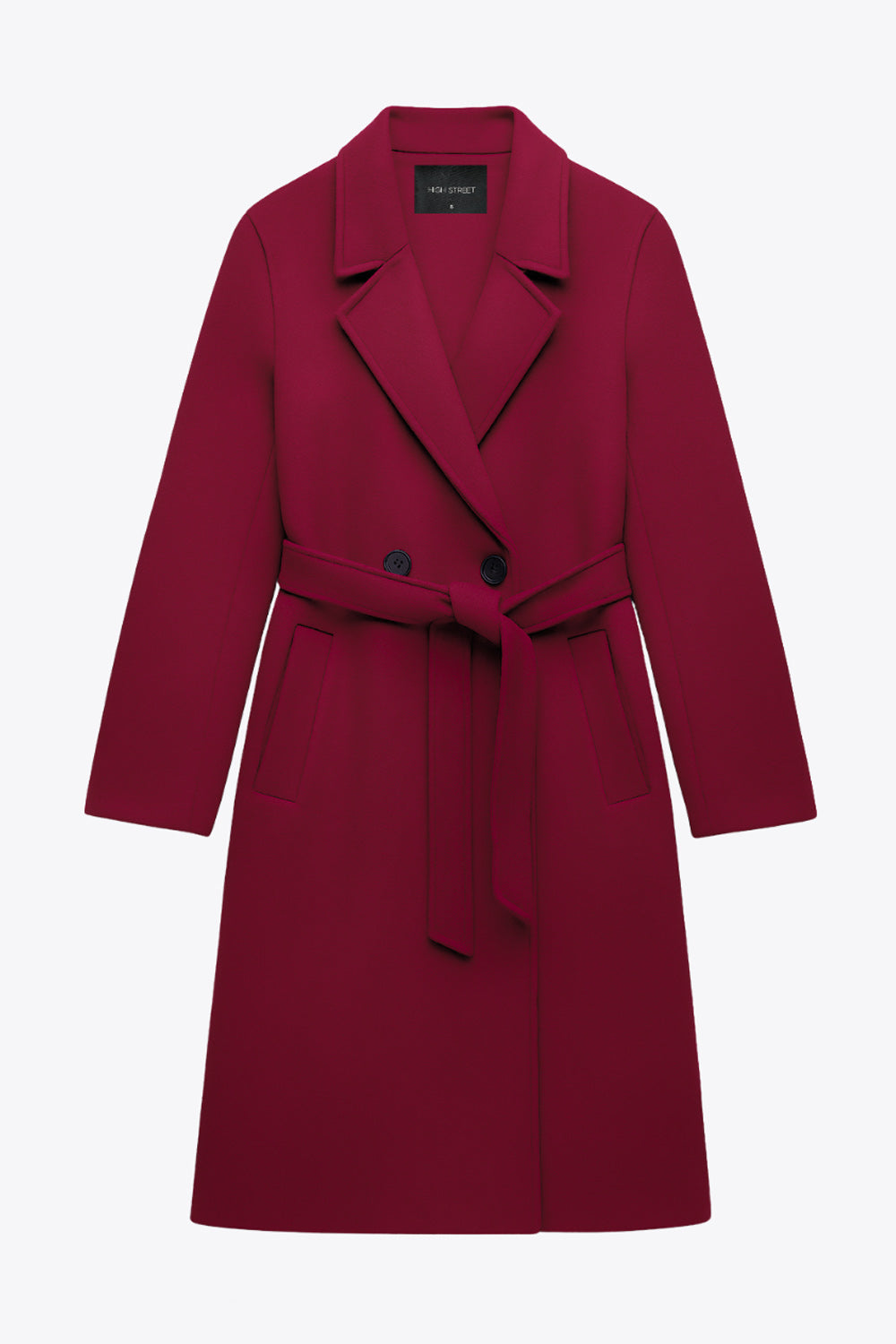 Abrigo largo de fit recto con solapa, manga larga con puños abotonados y bolsillos delanteros con vivos. Cierre frontal con doble cruce de botones. Detalle de abetura posterior en bajo, trabillas y cinturón amarrable del mismo tejido.