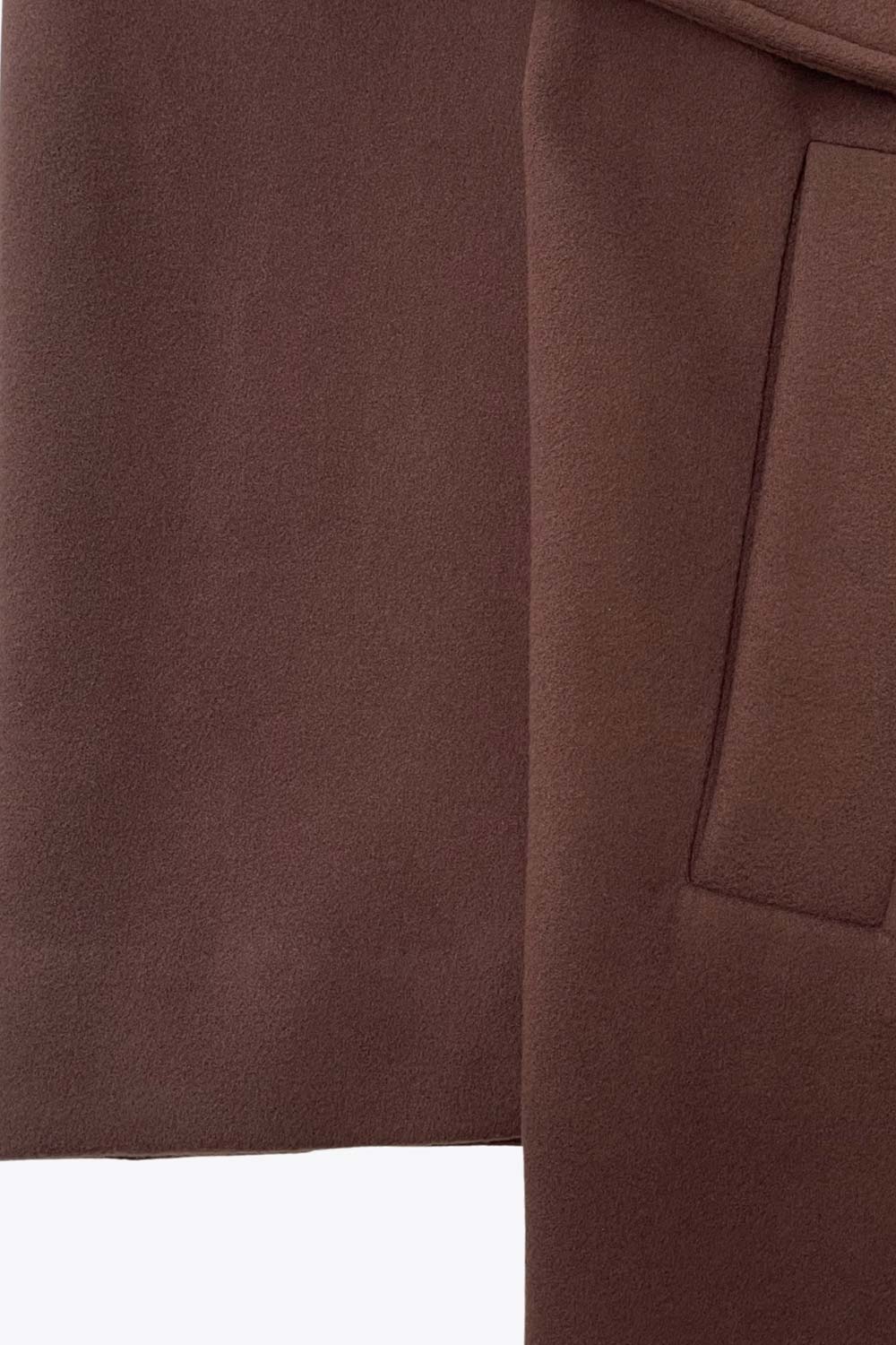 Abrigo largo de fit recto con solapa, manga larga con puños abotonados y bolsillos delanteros con vivos. Cierre frontal con doble cruce de botones. Detalle de abetura posterior en bajo, trabillas y cinturón amarrable del mismo tejido.