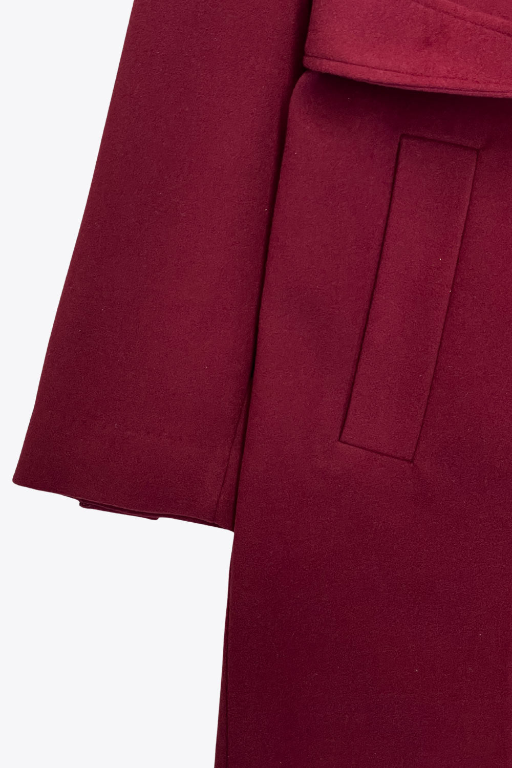 Abrigo largo de fit recto con solapa, manga larga con puños abotonados y bolsillos delanteros con vivos. Cierre frontal con doble cruce de botones. Detalle de abetura posterior en bajo, trabillas y cinturón amarrable del mismo tejido.