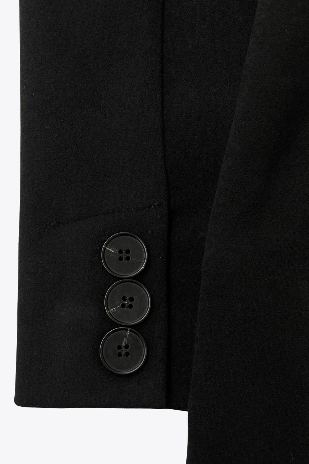 Abrigo largo de fit recto con solapa, manga larga con puños abotonados y bolsillos delanteros con vivos. Cierre frontal con doble cruce de botones. Detalle de abetura posterior en bajo, trabillas y cinturón amarrable del mismo tejido.