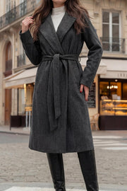 Abrigo largo de fit recto, estampado rayas, con solapa, bolsillos delanteros con vivos, manga larga con puño abotonado, trabillas y cinturón amarrable del mismo tejido. Detalle de abertura posterior en bajo.