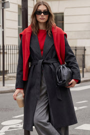 Abrigo largo de corte en a, con solapa, manga larga con puño abotonado en contraste y bolsillos frontales con cartera. Detalle de trabillas, cinturón amarrable del mismo tejido y abertura posterior.