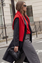 Abrigo largo de corte en a, con solapa, manga larga con puño abotonado en contraste y bolsillos frontales con cartera. Detalle de trabillas, cinturón amarrable del mismo tejido y abertura posterior.