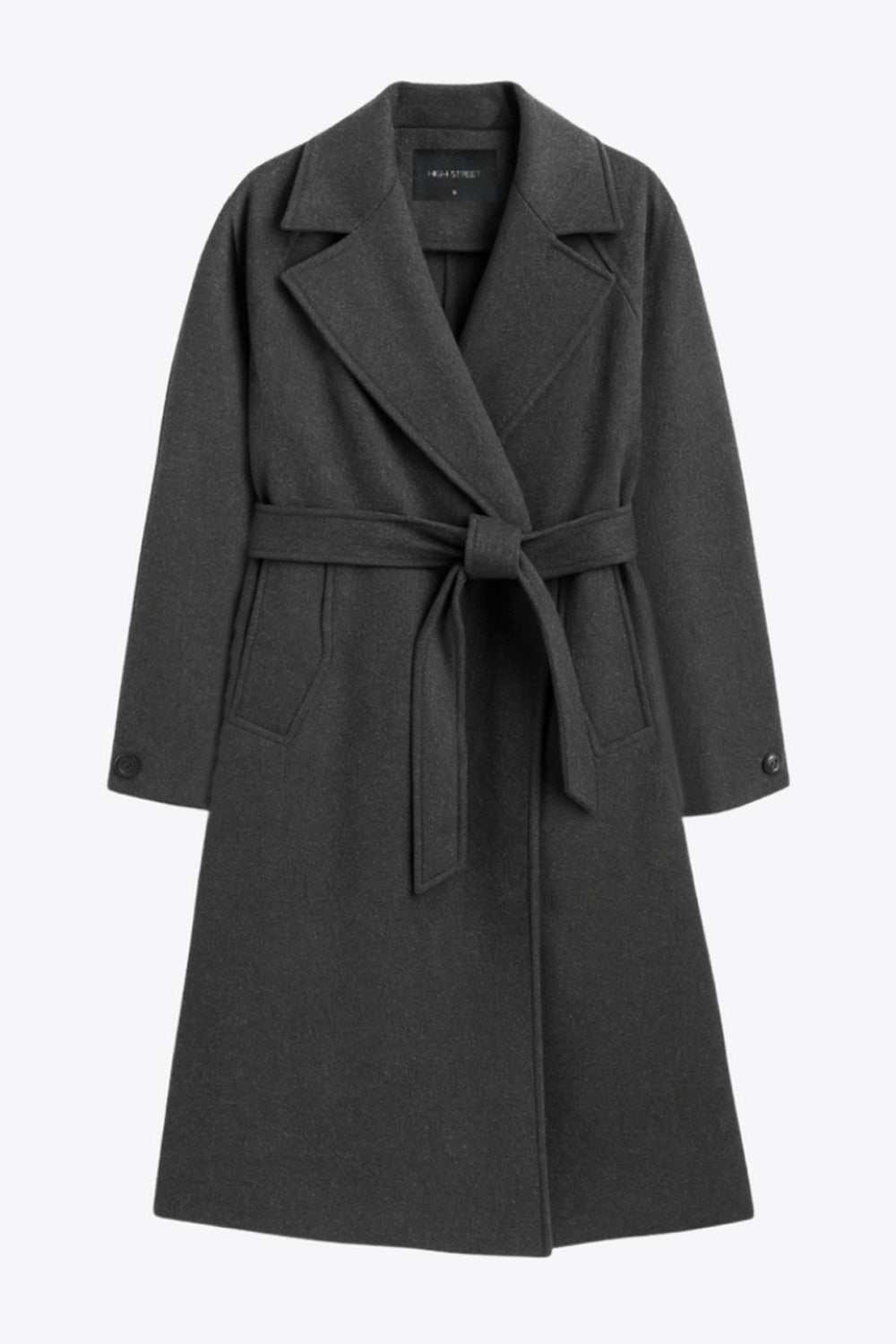 Abrigo largo de corte en a, con solapa, manga larga con puño abotonado en contraste y bolsillos frontales con cartera. Detalle de trabillas, cinturón amarrable del mismo tejido y abertura posterior.