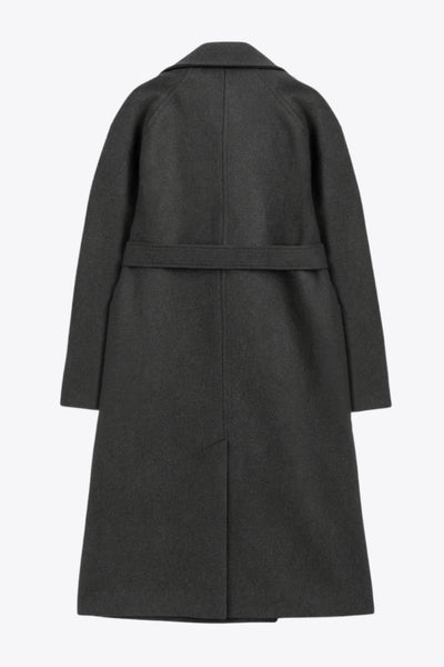 Abrigo largo de corte en a, con solapa, manga larga con puño abotonado en contraste y bolsillos frontales con cartera. Detalle de trabillas, cinturón amarrable del mismo tejido y abertura posterior.